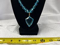 Front view of entire necklace on display bust showing bead strand and pendant