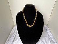 Necklace on black bust showing bead design and color