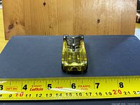 Overhead view showing transparent yellow body and overall length against tape measure