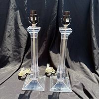 Front view of both clear acrylic lamp bases showing overall design and cords