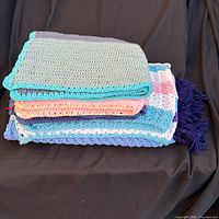 Stack of all five folded crocheted blankets