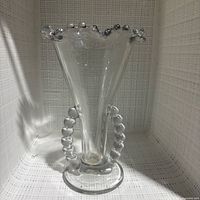 Front view of clear glass Candlewick vase showing beaded rim, handles and base