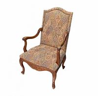 Front three-quarter view showing carved walnut frame and tapestry upholstery