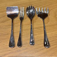 Front view of four Godinger serving utensils