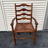 Front view of ladder-back armchair showing overall design and rush seat