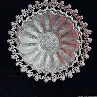 Top view showing scalloped form, repousse pattern and openwork rose rim
