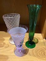 Front view of three glass vases standing side by side