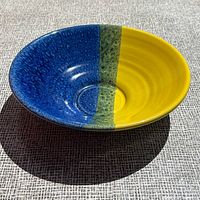 Angled top view showing blue and yellow glaze with green stripe inside bowl