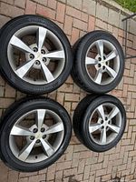 Set of four Chevrolet alloy wheels with Hankook tires on paving stone