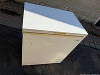Front and top view of white chest freezer showing logo and handle