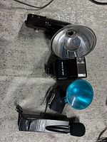 Lot overview showing handheld flash with reflector, Black's AF 660 flash, Action Mike EC-203 microphone, blue diffuser
