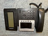 Front view of Grandstream GXP2160 phone showing handset, keypad, colour LCD, expansion display and coiled cord