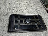 Front view of folded camera showing Art Deco faceplate and lens opening