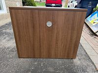 Rear view of desk showing wood grain laminate finish and cable grommet