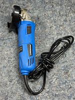 Blue corded power tool with safety guard and disc mount visible