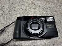 Front view of Pentax Zoom 90 camera showing lens, flash, branding