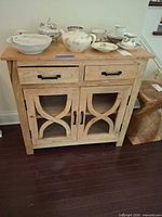 Front view of wood cabinet showing drawers, doors and top surface