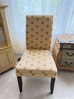 Front view of upholstered dining chair showing full shape and upholstery