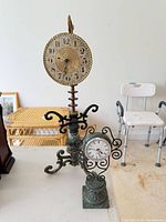 Both metal stand clocks side by side on table
