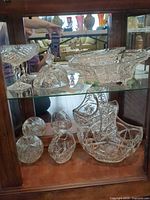 Group of crystal items on two cabinet shelves