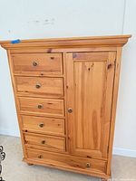 Front view of dresser showing six drawers, cabinet door, hardware, finish
