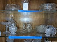 Shelves with assorted pressed glass pieces