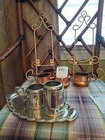 Full set showing easel stands, copper cups, silver tray with creamer and cup