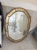 Front view of the oval beveled mirror with etched border and gold-tone frame