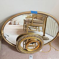 All three mirrors: large metal-framed mirror behind two smaller gilt mirrors