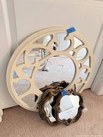 Front view showing large round mirror and three small mirrors