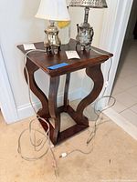 Full view of dark wooden side table with curved legs and open shelf