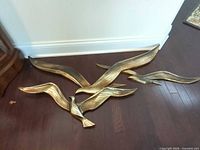 Front view of five gold-tone seagull wall plaques