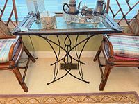 Full view of table between chairs showing mirrored tray top and metal base