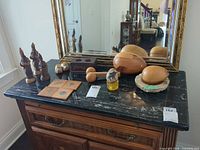 Group view of all wooden and stone decor items on dresser top