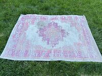 Entire rug laid out on grass showing full design and size