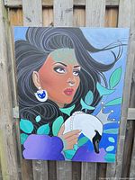 Full view of acrylic portrait painting on stretched canvas against fence