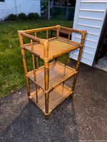 Front angled view of entire bamboo and rattan étagère showing three shelves