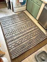Full view of beige rug with black geometric pattern in kitchen setting