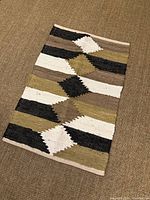 Full view of rug showing color palette and geometric striped pattern