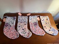 Four quilted floral oven mitts laid out side by side