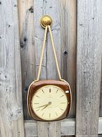 Front view of Junghans wall clock hanging by rope strap
