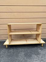 Front view of unfinished two-shelf unit on tapered legs