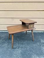 Front angled view of the two-tier side table showing starburst accent and tapered legs
