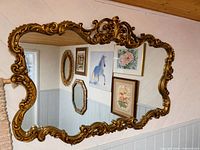 Front view of ornate gold Rococo mirror hanging on wall