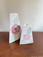 Front view of both ceramic candle holders displaying floral motif and relative size