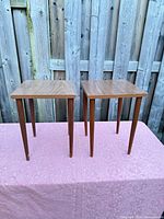Two matching square top side tables on display