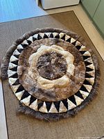 full view of round patchwork sheepskin rug on floor