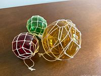 All three glass floats grouped on tabletop showing colors and nets