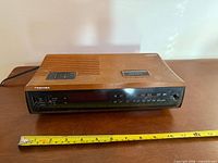 Front view of Toshiba clock radio with measuring tape showing width