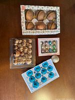 Boxes and trays of assorted glass ornaments on table